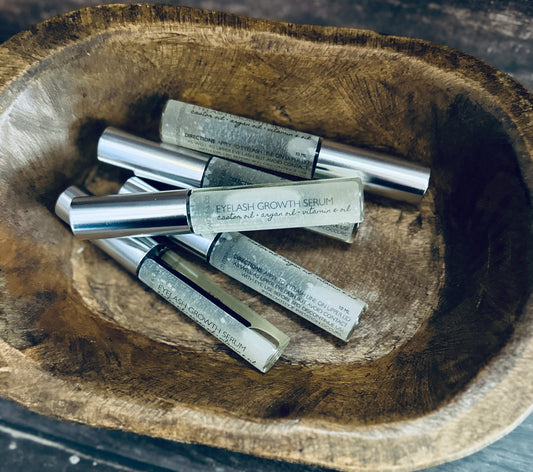 a wooden bowl filled with metal tubes on top of a table