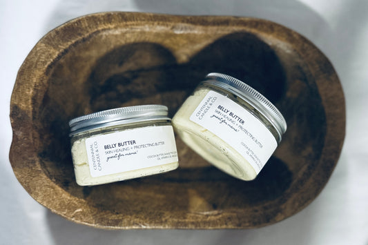 two jars of body butter in a wooden bowl