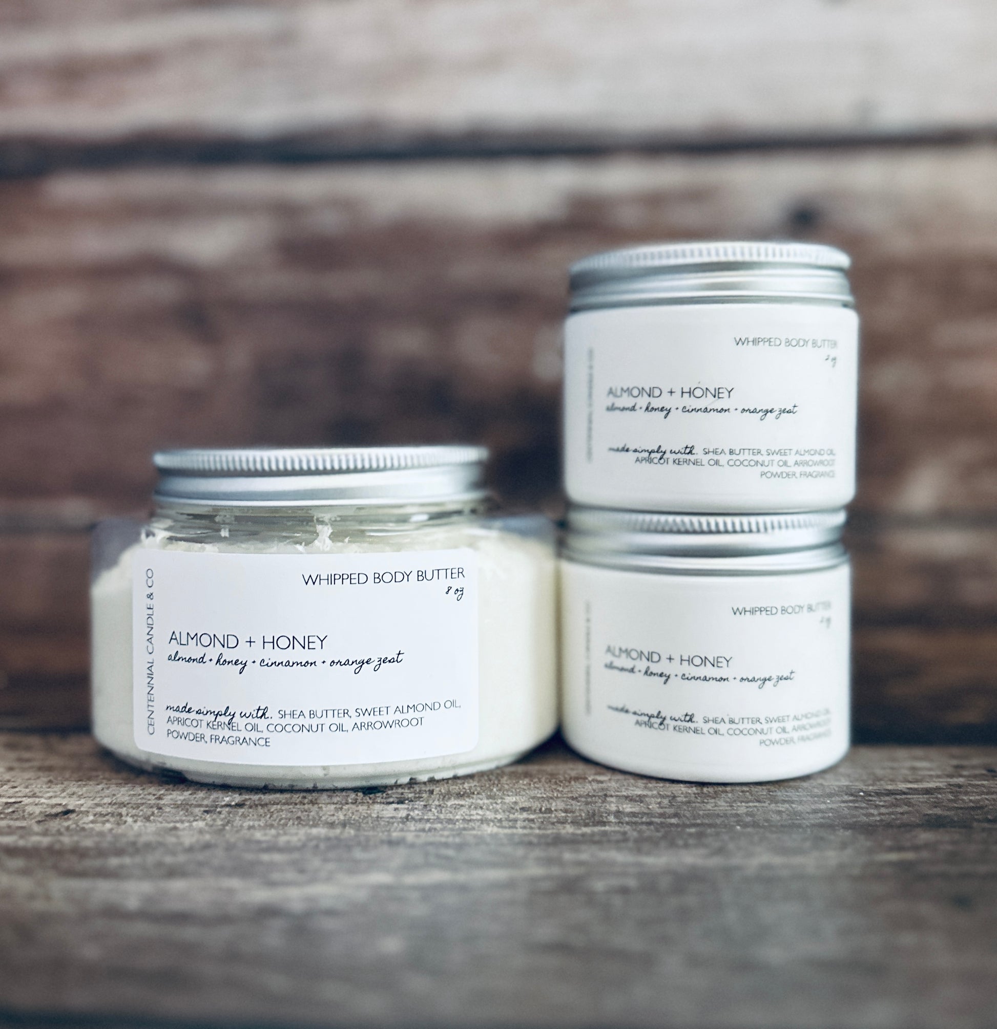 three jars of whipped butter sitting on a wooden table